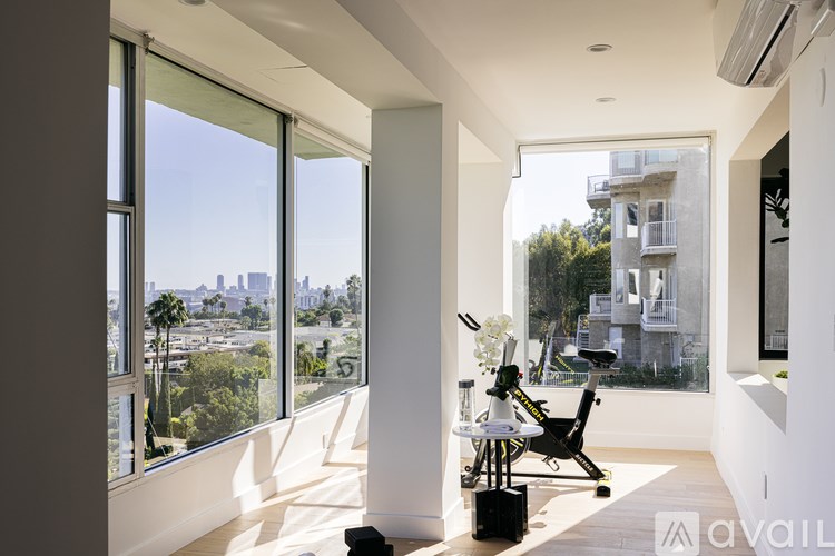 A modern living room with a view of the cityscape outside the large windows.