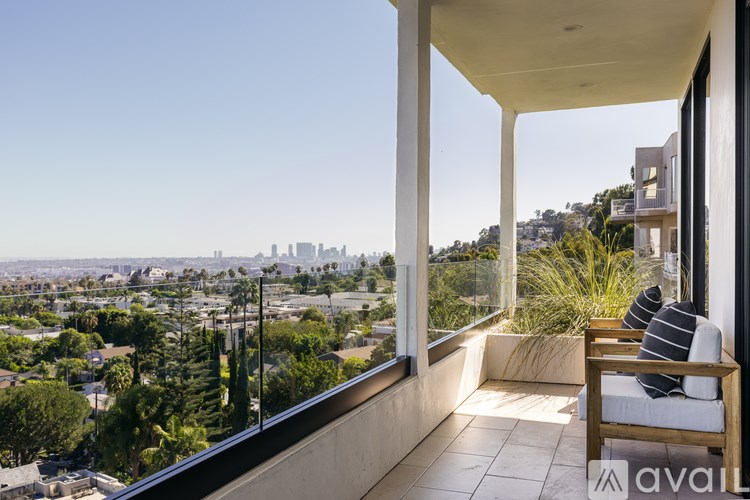 A balcony with a chair and a view of a city skyline.
