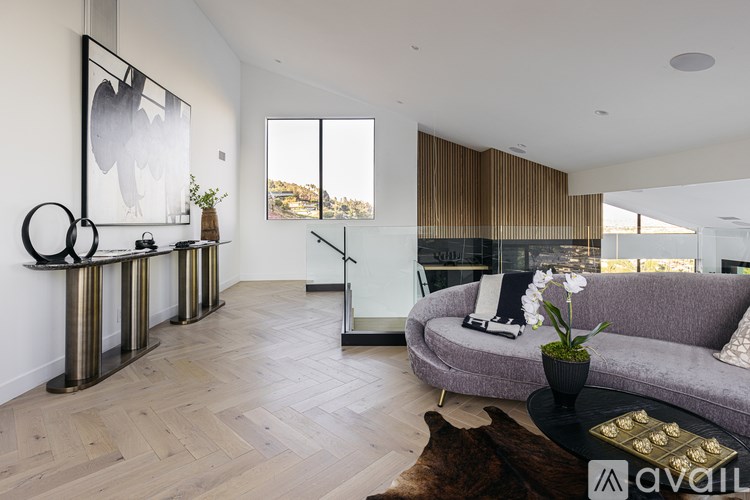A modern living room with a grey sofa and a wooden floor.