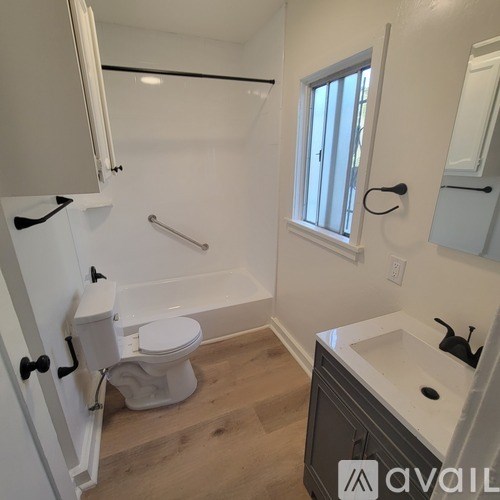 A bathroom with a toilet, sink, and bathtub.
