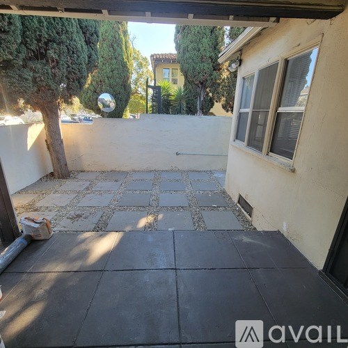 A patio with a black tiled floor and a white wall.