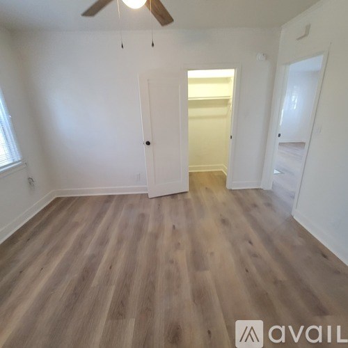 A room with wooden flooring and a ceiling fan.