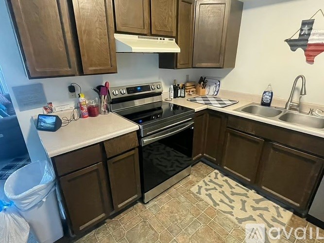 A kitchen with brown cabinets and a black oven.