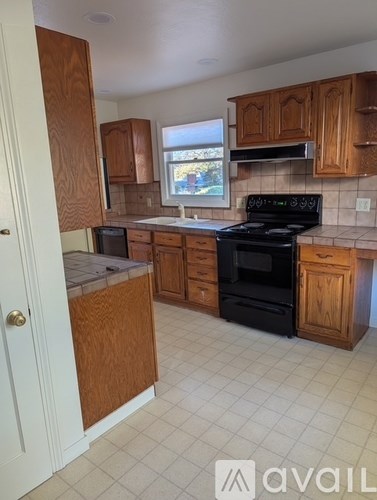 A kitchen with wooden cabinets and a black stove top oven.