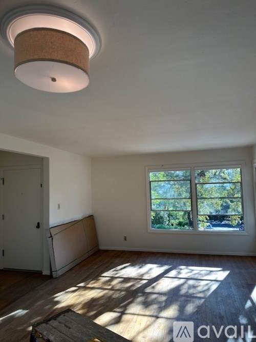 A room with a window and a wooden floor.
