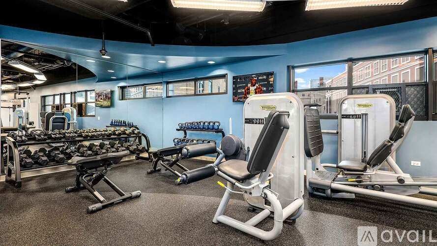 A gym with a variety of equipment including weights and machines.