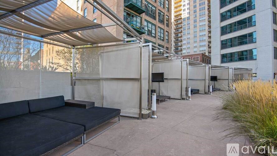 A patio area with a couch and a table under a shade structure.