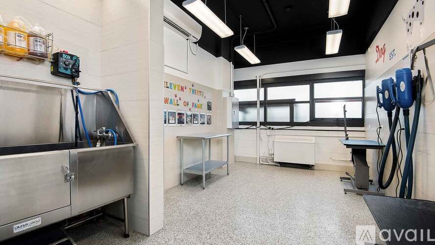 A clean, empty industrial kitchen with stainless steel appliances and white walls.