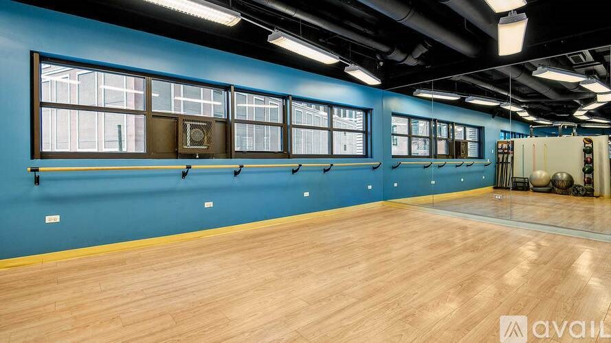 A gym with blue walls and wooden floors.