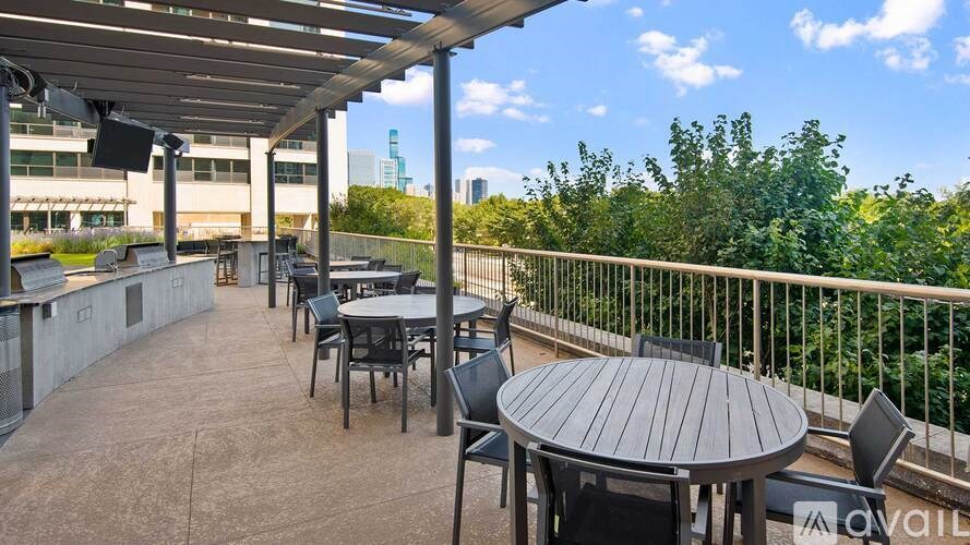 A patio with a table and chairs overlooking a cityscape.