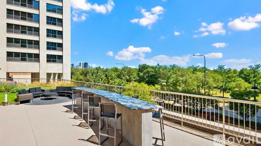 A sunny day at the rooftop terrace with chairs and a railing.