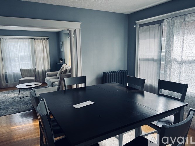 A black dining table surrounded by chairs in a room.