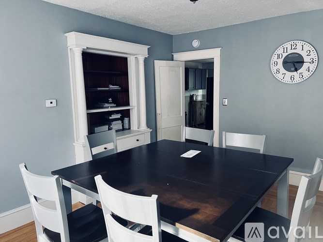 A dining room with a large table and chairs.