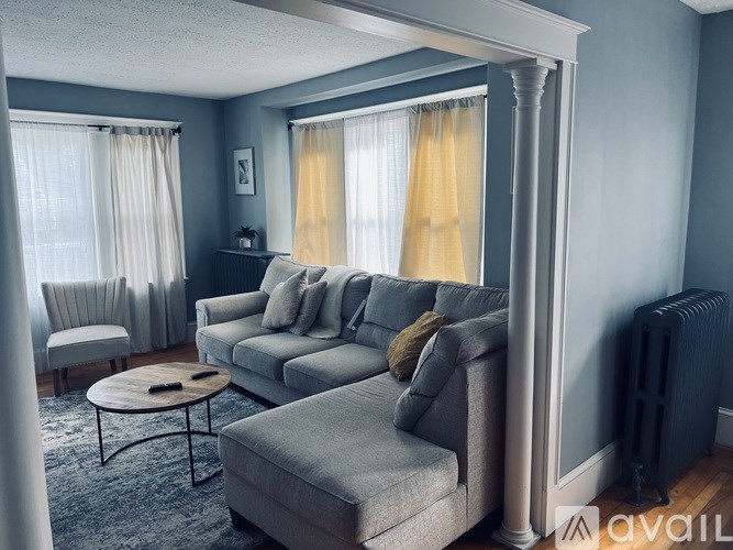 A living room with a grey couch and a coffee table.