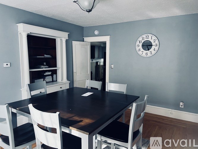 A dining room with a table and chairs.