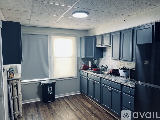 A kitchen with black cabinets and a white fridge.