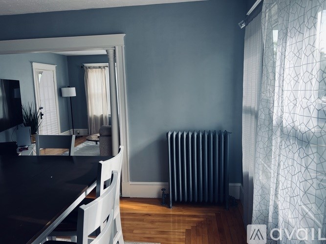 A dining room with a black table and white chairs.