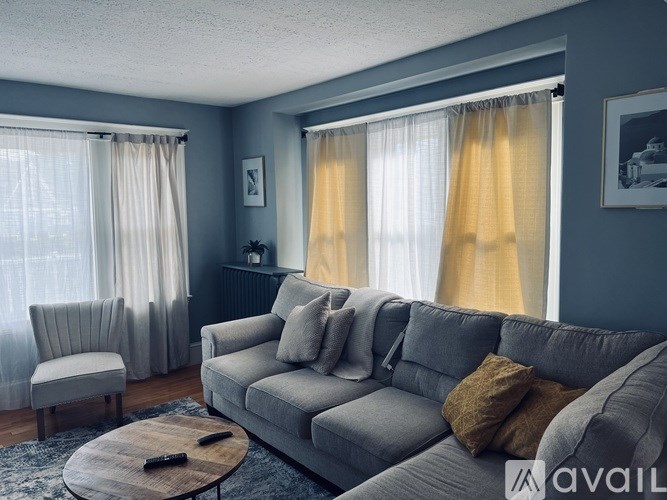 A living room with a grey couch and a wooden coffee table.