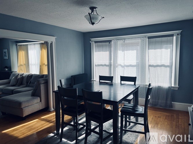 A dining room with a table and chairs.