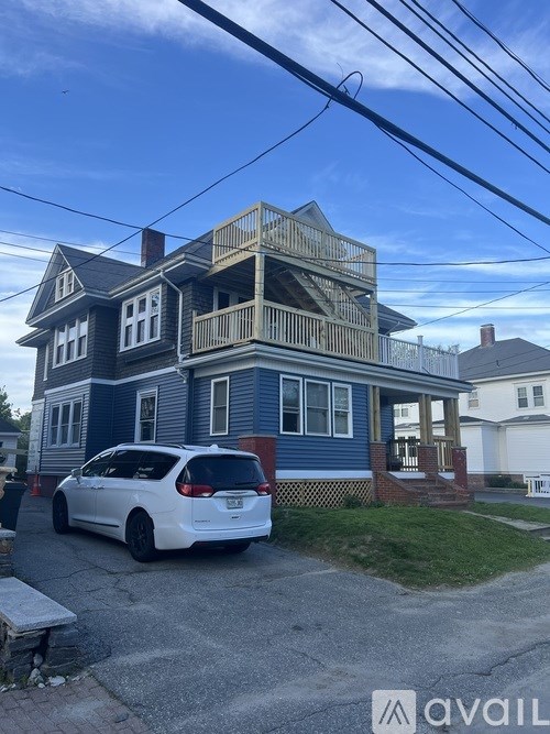 A house with a blue exterior and a white car parked in front.