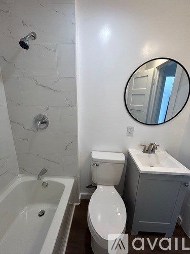 A bathroom with a toilet, sink, and tub.