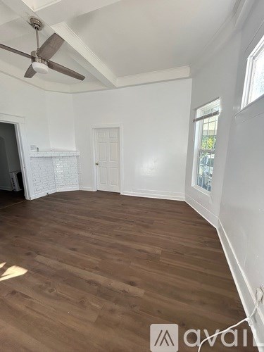 A room with wooden flooring and a ceiling fan.