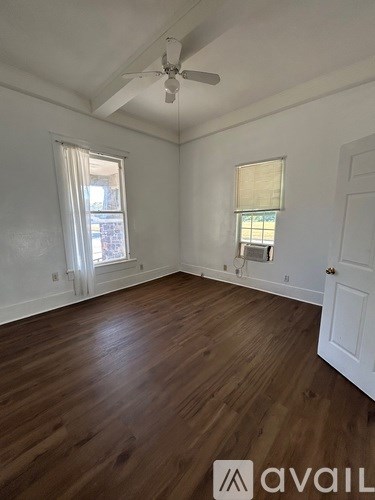 A room with wooden floors and a ceiling fan.