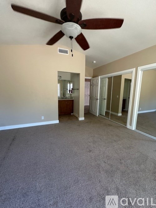 A room with a ceiling fan and a carpeted floor.