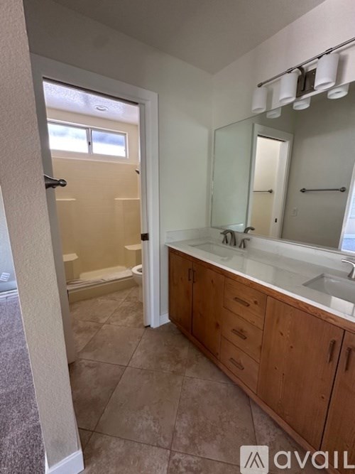 A bathroom with a sink, mirror, and shower.