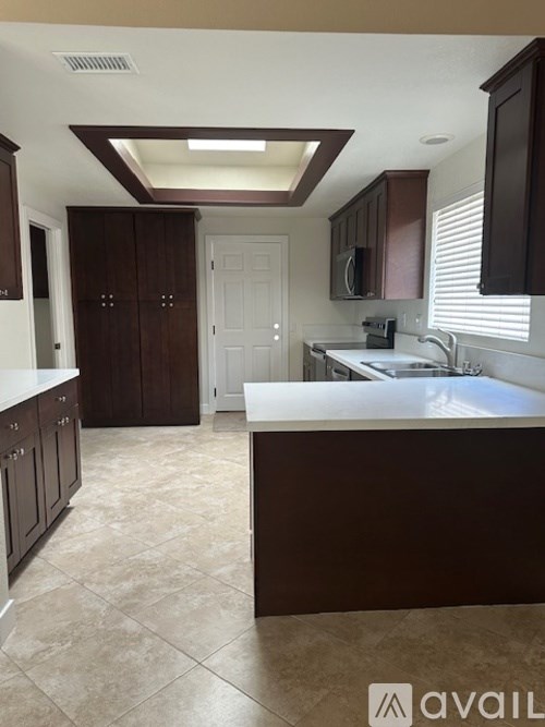 A kitchen with brown cabinets and a white counter.