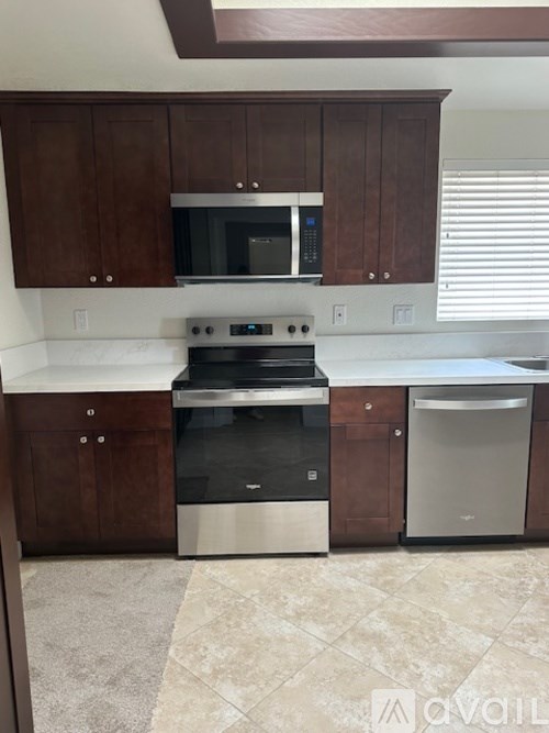 A kitchen with brown cabinets and a stainless steel dishwasher.
