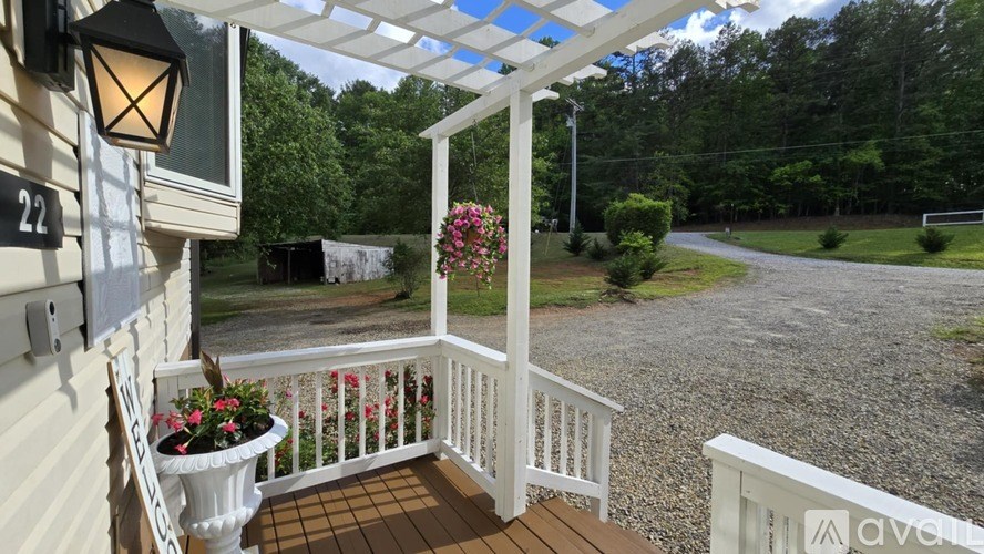 A porch with a white railing and a lamp on the wall.