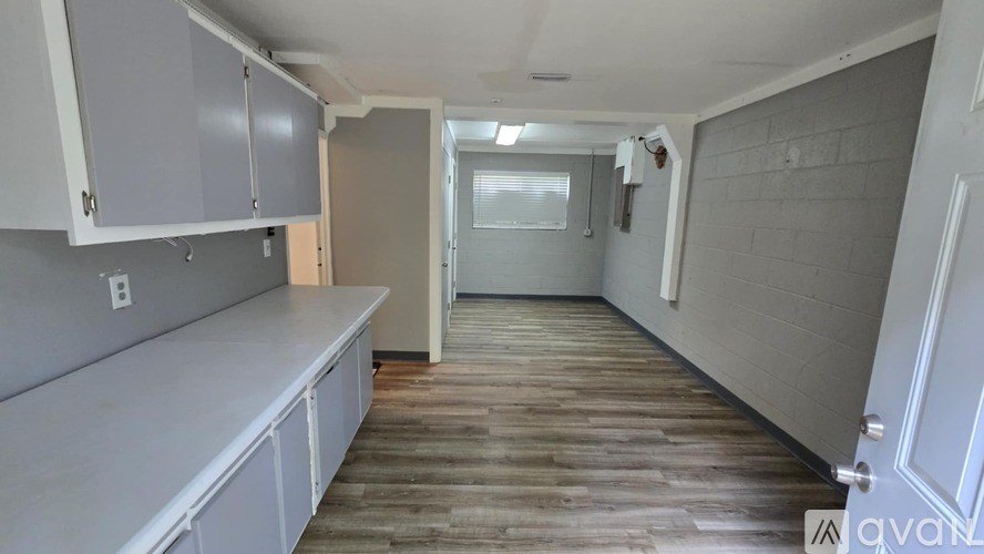 A kitchen with wooden floors and white cabinets.