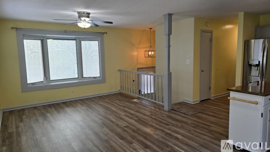 A room with a ceiling fan and a window.