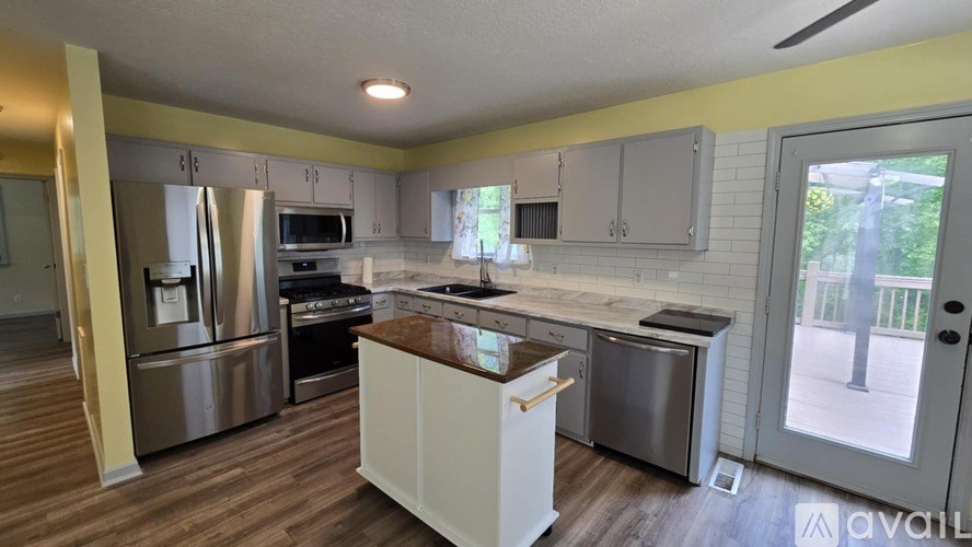 A kitchen with stainless steel appliances and wooden floors.