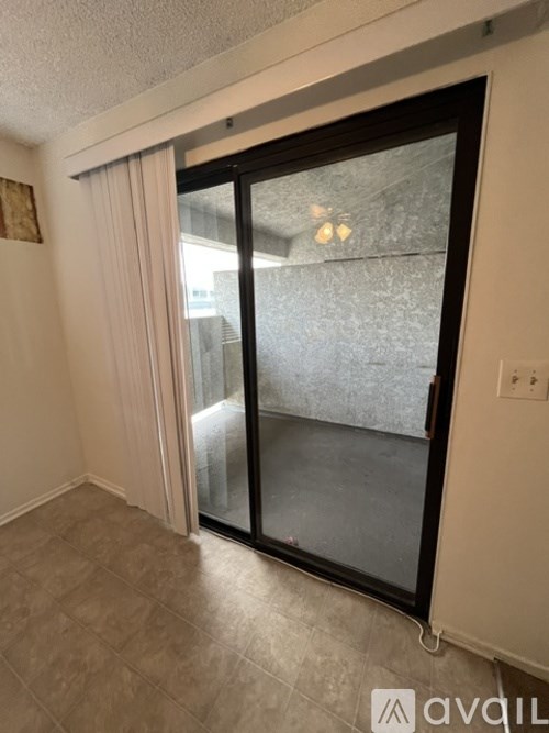 A room with a sliding glass door and a tiled floor.
