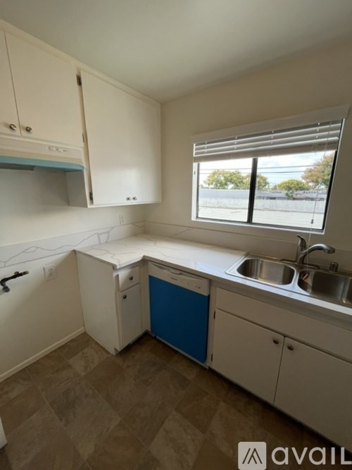 A kitchen with white cabinets and a blue drawer.