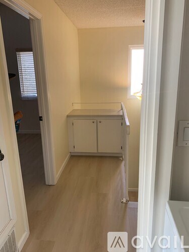 A hallway with a cabinet and a door.