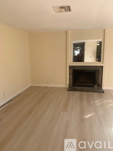A living room with a fireplace and a flat screen TV mounted on the wall.
