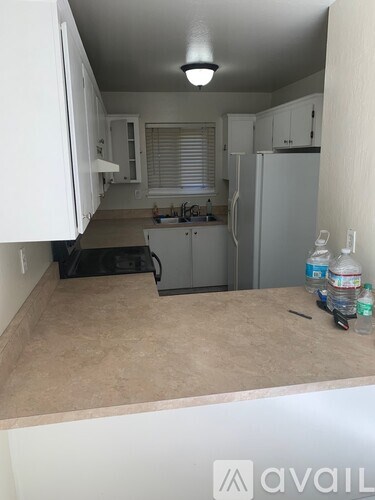 A kitchen with white cabinets and a countertop with a few items on it.