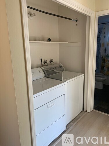A small white laundry room with a washer and dryer.