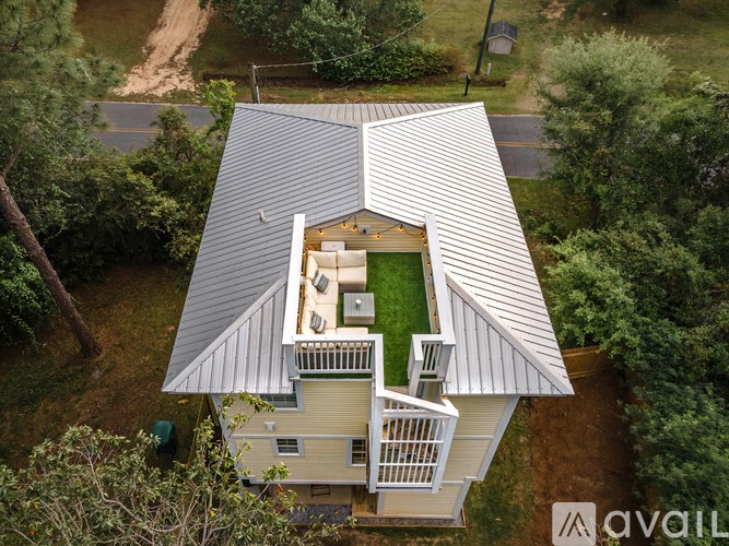A house with a metal roof and a green lawn in the front.