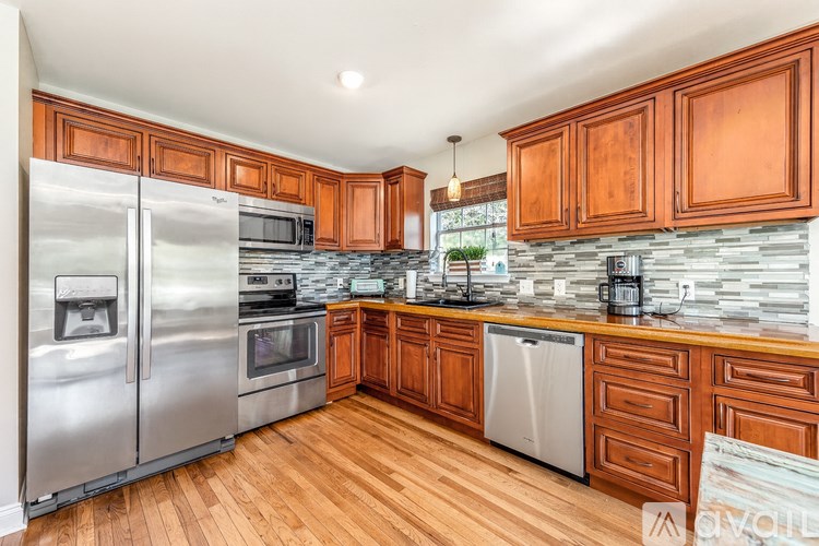 A kitchen with wooden cabinets and a stainless steel refrigerator.