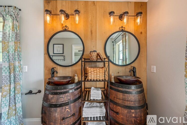 A bathroom with wooden walls and barrel-shaped sinks.