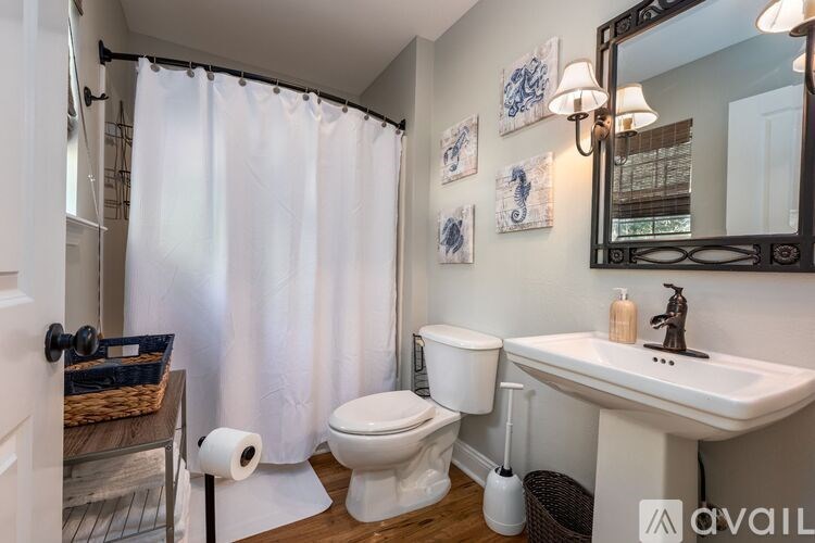 A bathroom with a toilet, sink, and shower.