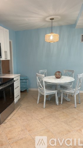 A kitchen with a table and chairs.