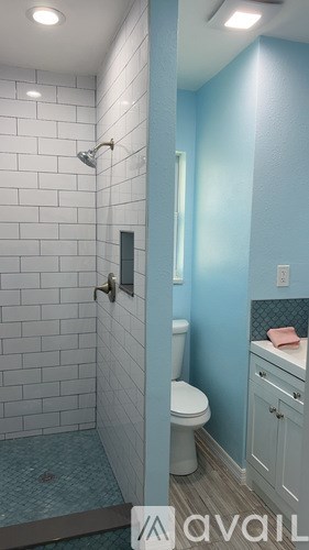 A bathroom with a toilet, sink, and shower.