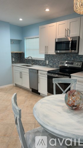 A kitchen with a table and chairs in the foreground.