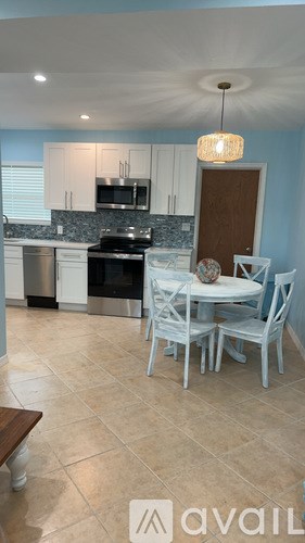 A kitchen with a table and chairs.