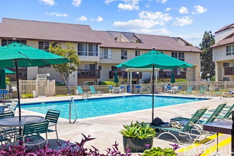 A pool area with green umbrellas and chairs.